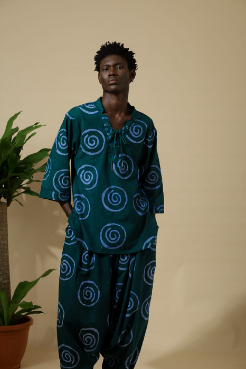Male model wearing Cute Saint Irin-Ajo teal spiral batik lace-up top and matching harem pants