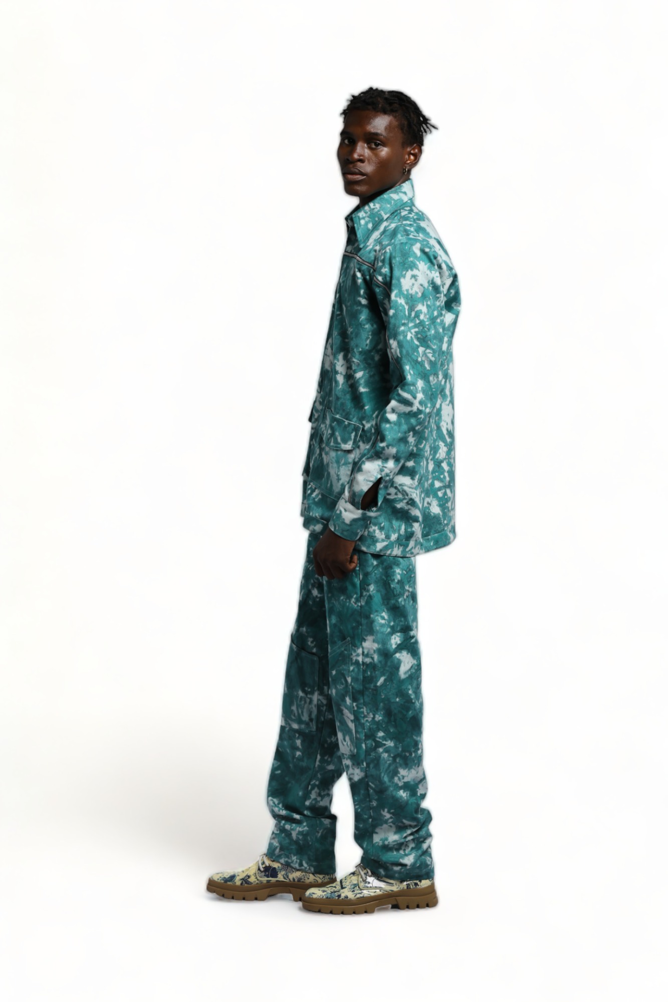 Side view of a model waering the Men’s teal and white tie-dye Kolo Shacket with matching utility trousers.