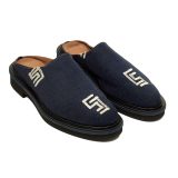 Angled view of Bata Mules in dark indigo denim textile featuring white graphic logos on the side and toe.